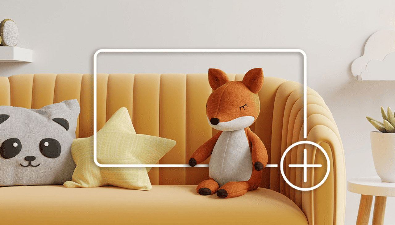 Yellow sofa with a plush fox toy sitting beside a panda-face pillow and a yellow star-shaped cushion against a neutral wall. 