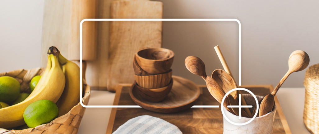 Wood kitchenware on a countertop. Items are outlined by a white box and plus sign graphic that indicates adding to an online shopping cart.